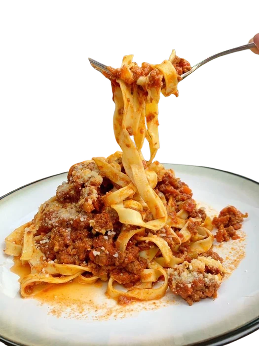Pasta being lifted from a plate of bolognese at SLYCE Pizza Cafe